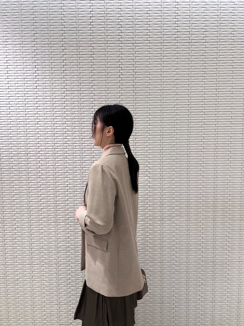 ピンク系のニット/セーター、ブラック系のブーツ、ベージュ系のテーラードジャケットを着用したレディースの秋コーディネートの5枚目の写真