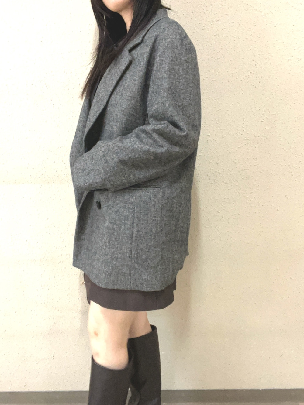 ブラウン系のブーツ、ブラック系のスカート、グレー系のテーラードジャケットを着用したレディースの秋コーディネートの5枚目の写真