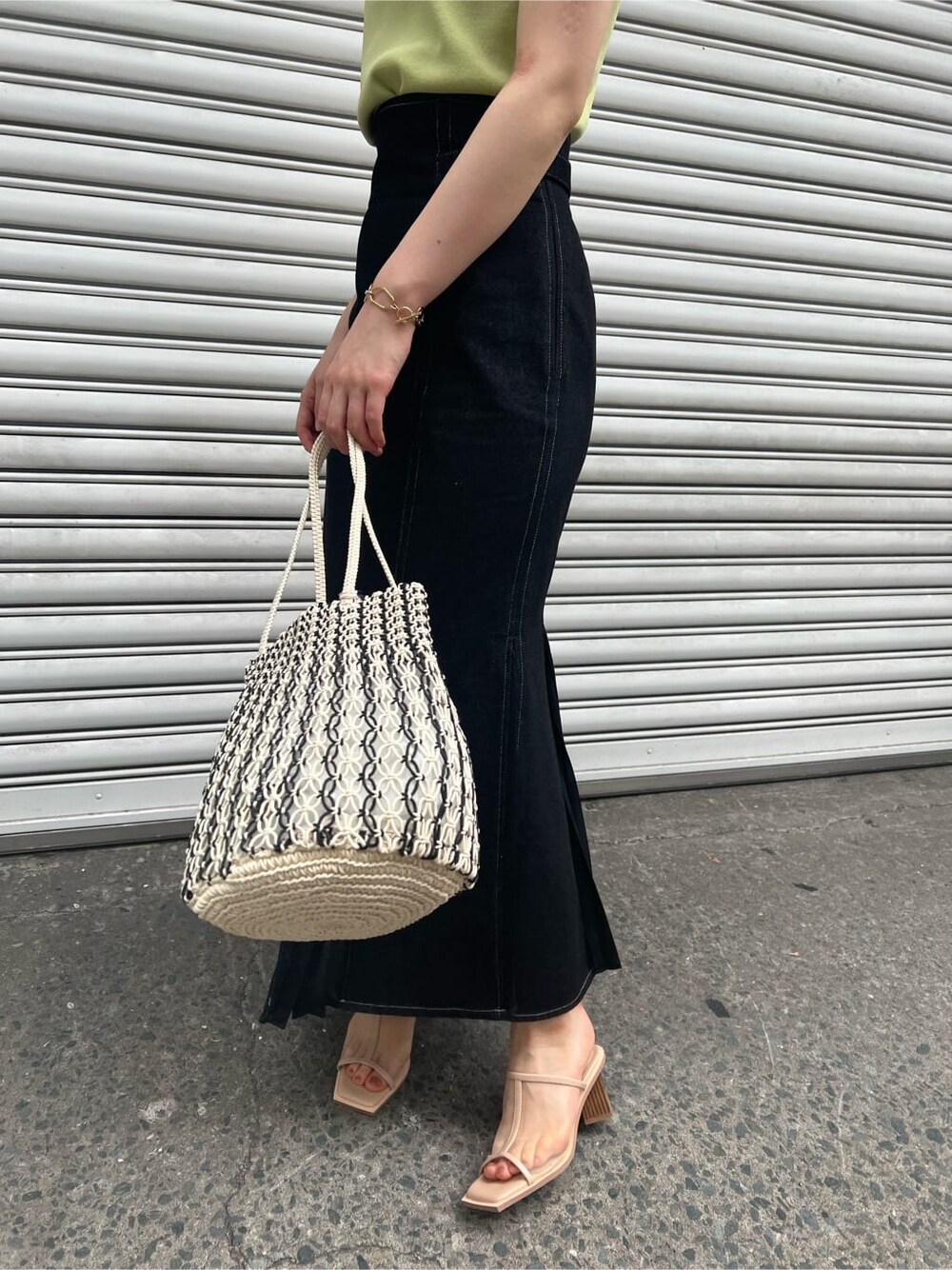 ブルー系のスカート、ベージュ系のサンダル、イエロー系のニット/セーターを着用したレディースの春コーディネートの9枚目の写真