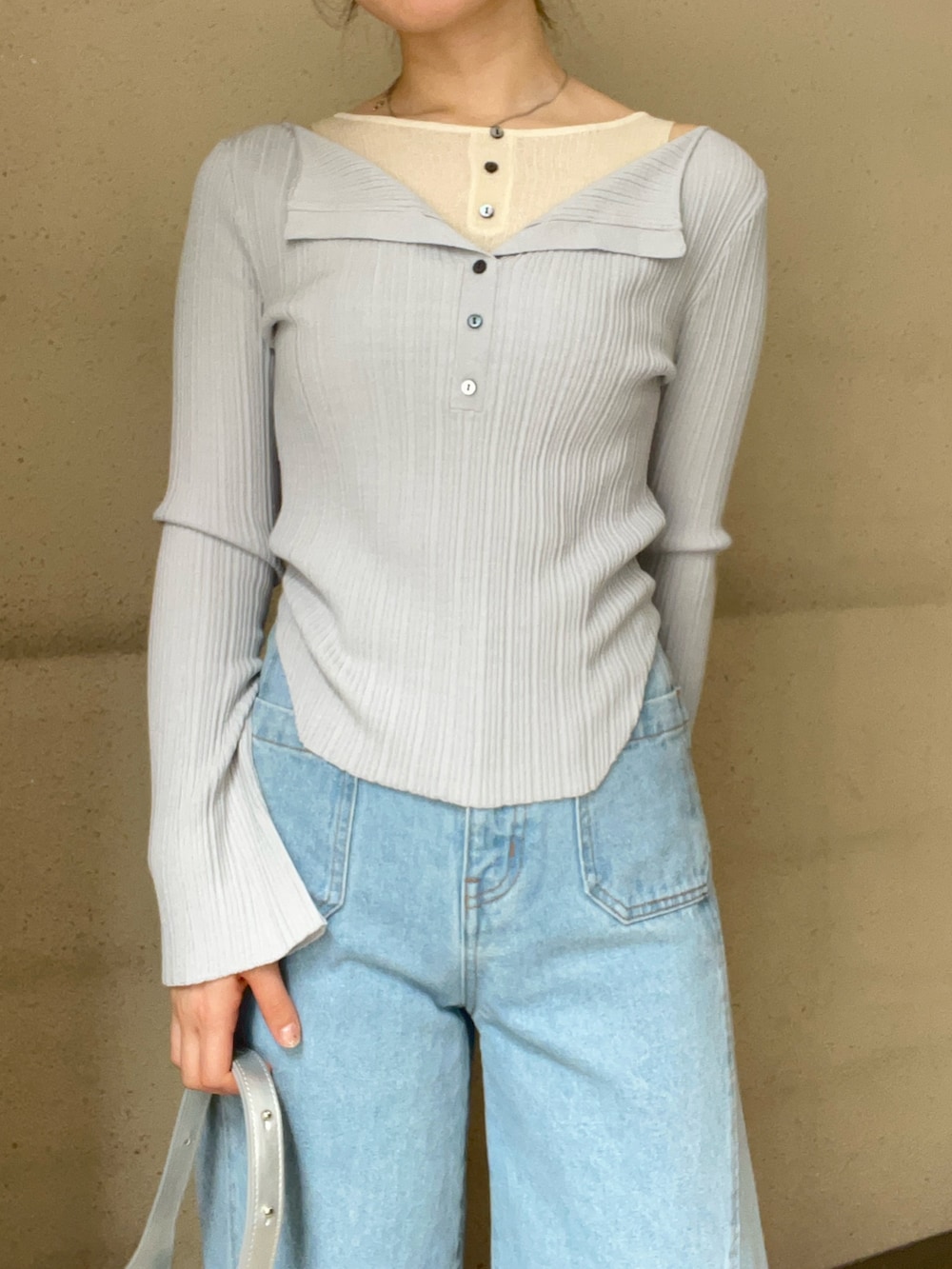 グレー系のニット/セーター、ブルー系のデニムパンツ、ブラック系のパンプスを着用したレディースの春コーディネートの4枚目の写真