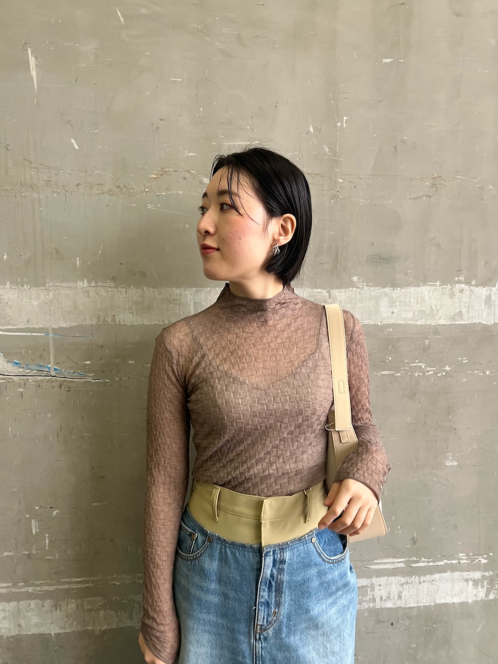 シルバー系のパンプス、グリーン系のテーラードジャケット、グリーン系のデニムスカートを着用したレディースの冬コーディネートの7枚目の写真