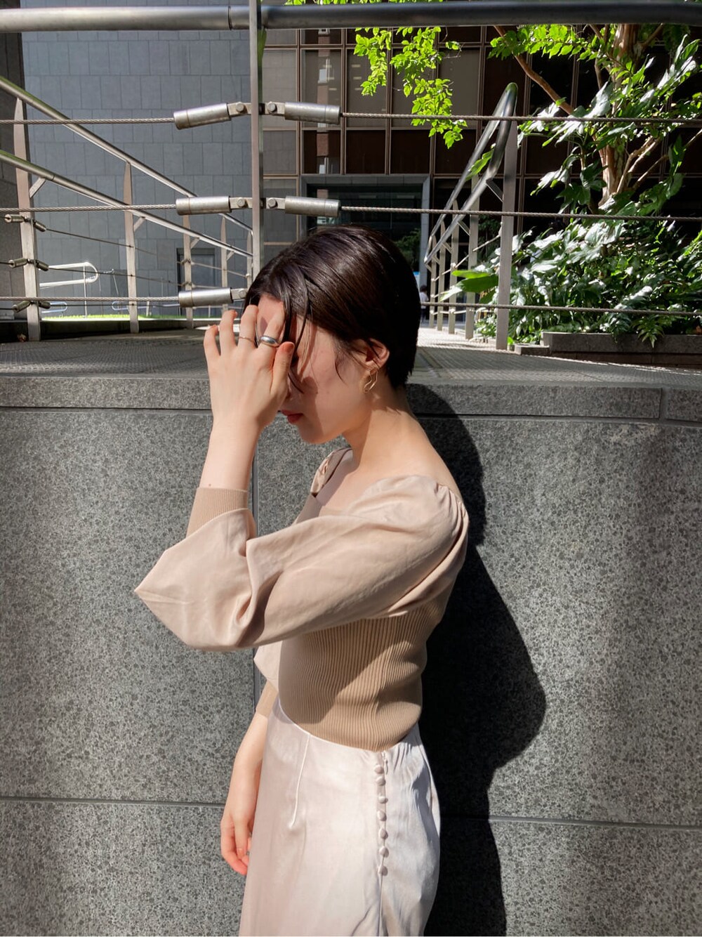 ホワイト系のスカート、ベージュ系のブーツ、ブラウン系のショルダーバッグを着用したレディースの秋コーディネートの6枚目の写真