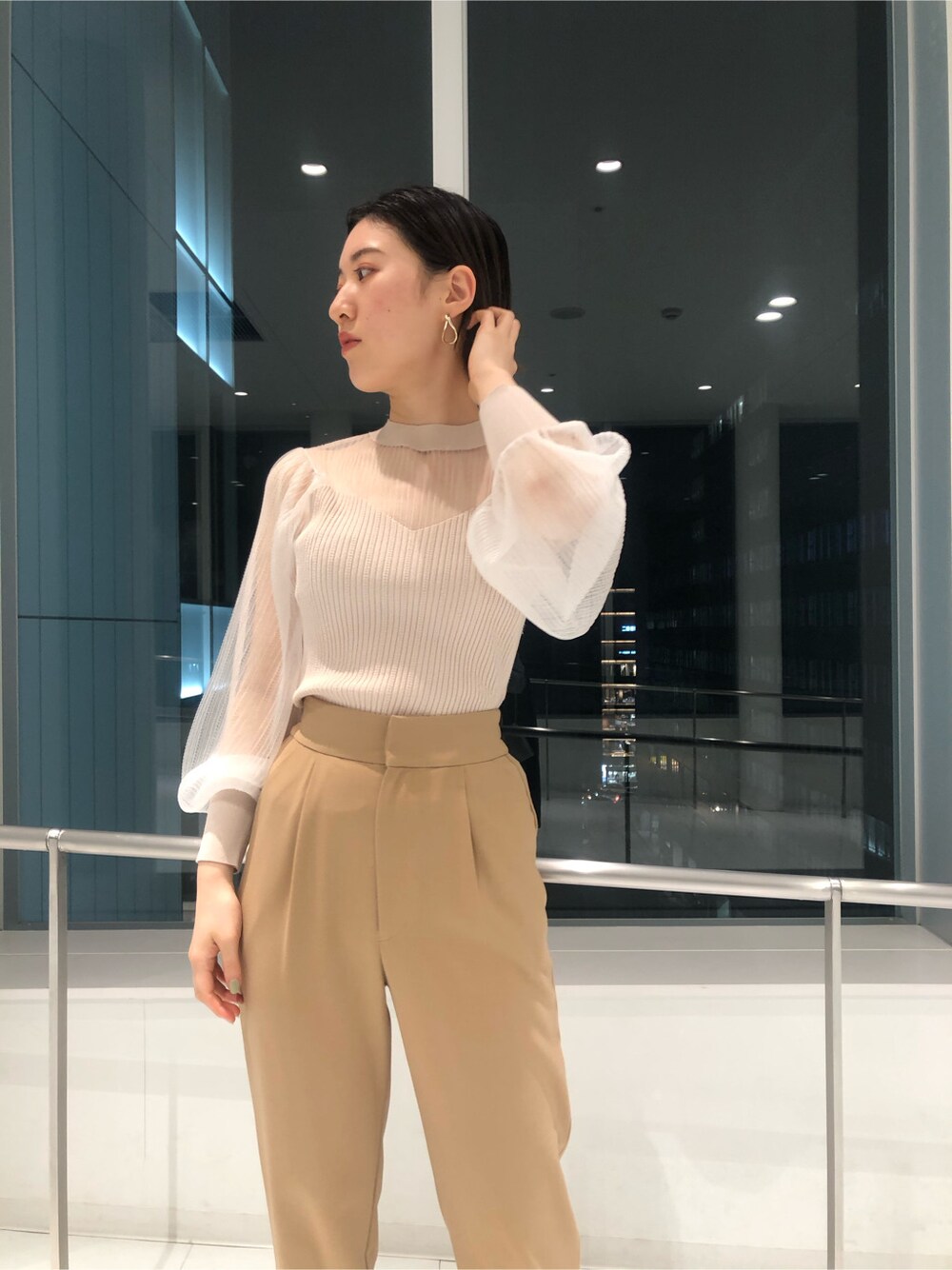 ベージュ系のその他アウター、パープル系のサンダル、パープル系のハンドバッグを着用したレディースの冬コーディネートの6枚目の写真