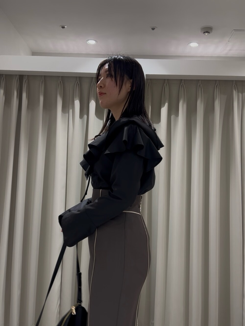 ホワイト系のシャツ/ブラウス、グレー系のスカート、ブラック系のショルダーバッグを着用したレディースの春コーディネートの5枚目の写真