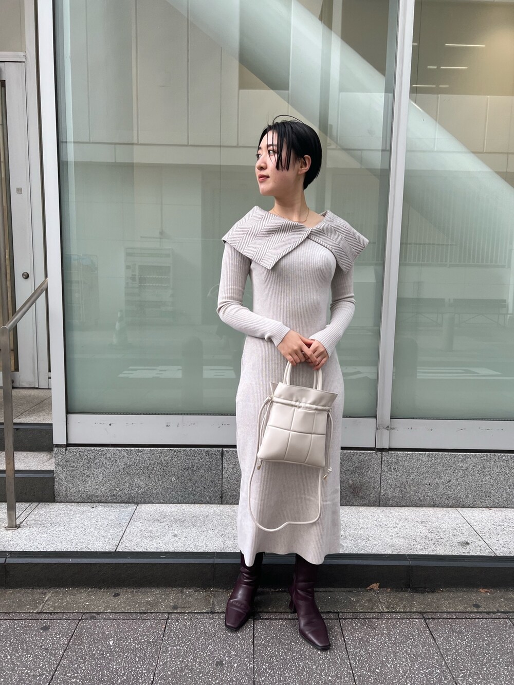 ホワイト系のワンピース、ホワイト系のカーディガン/ボレロ、レッド系のブーツを着用したレディースの冬コーディネートの6枚目の写真