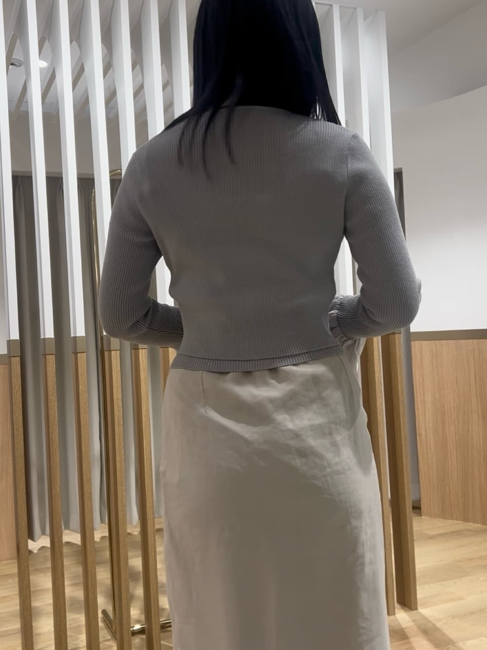 ホワイト系のスカート、グレー系のアンサンブル、ホワイト系のサンダルを着用したレディースの春コーディネートの6枚目の写真