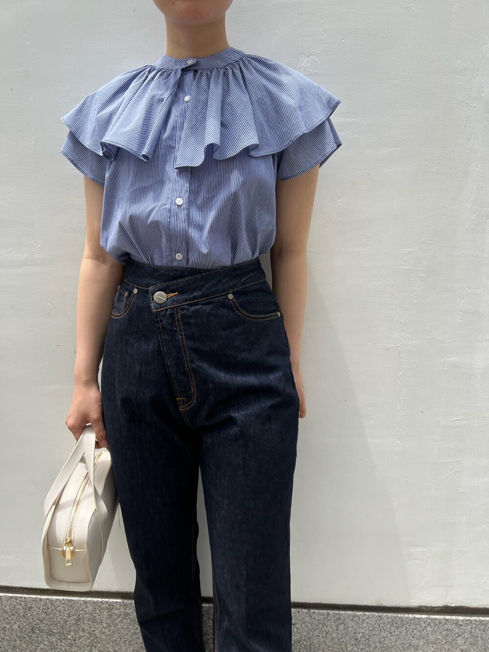 ベージュ系のサンダル、ホワイト系のショルダーバッグ、ブルー系のデニムパンツを着用したレディースの夏コーディネートの5枚目の写真