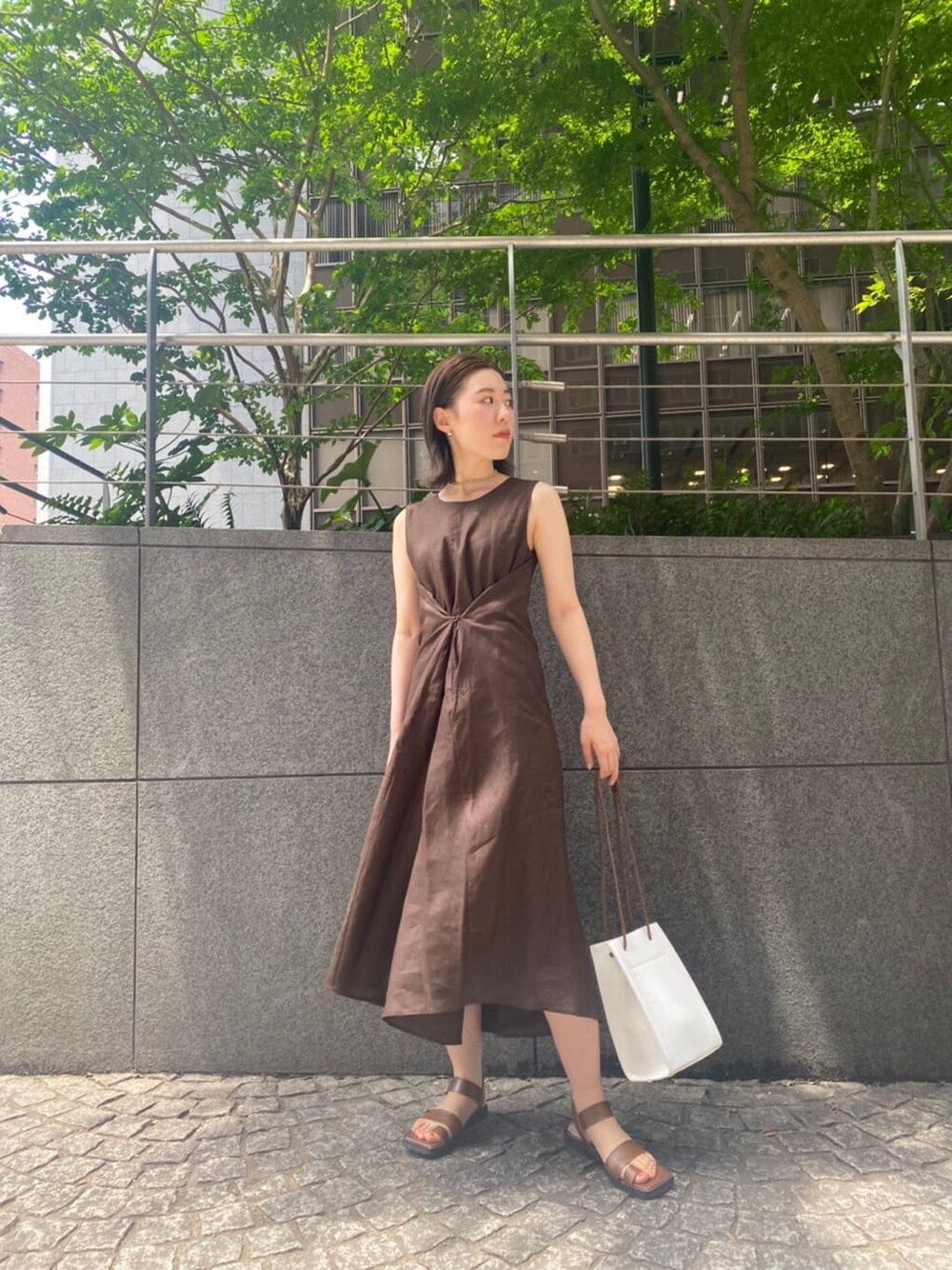 ホワイト系のハンドバッグ、ブラウン系のサンダル、ブラウン系のワンピースを着用したレディースの夏コーディネートの6枚目の写真