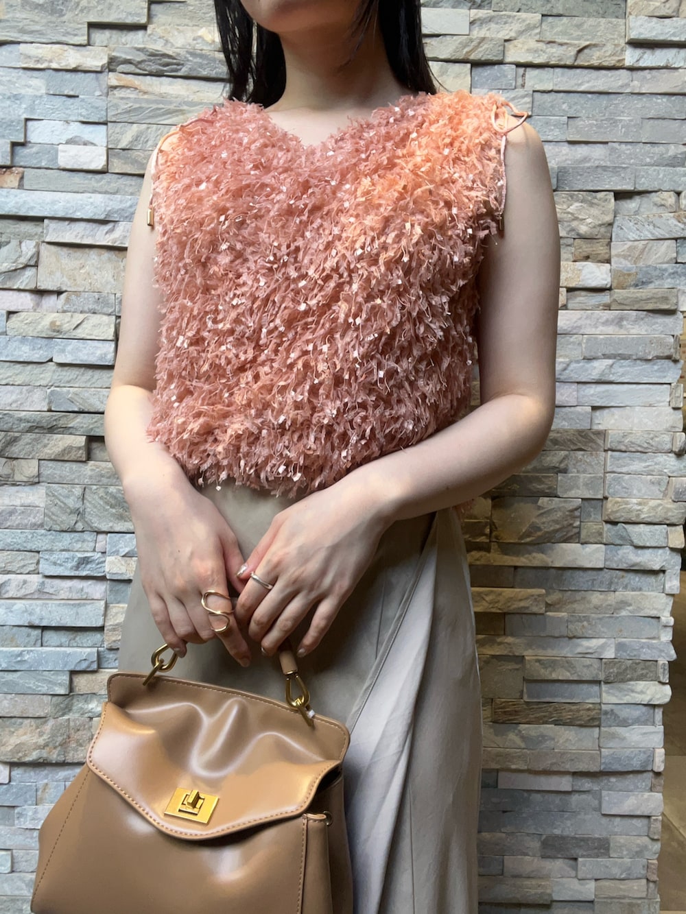 オレンジ系のTシャツ/カットソー、ベージュ系のスカート、ホワイト系のサンダルを着用したレディースの夏コーディネートの6枚目の写真