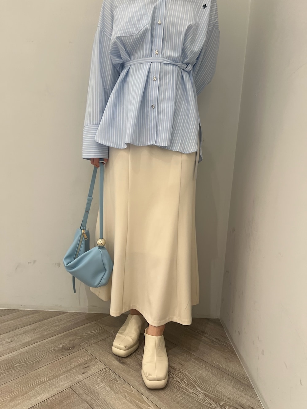 ブルー系のシャツ/ブラウス、ホワイト系のサンダル、ブルー系のショルダーバッグを着用したレディースの春コーディネートの7枚目の写真