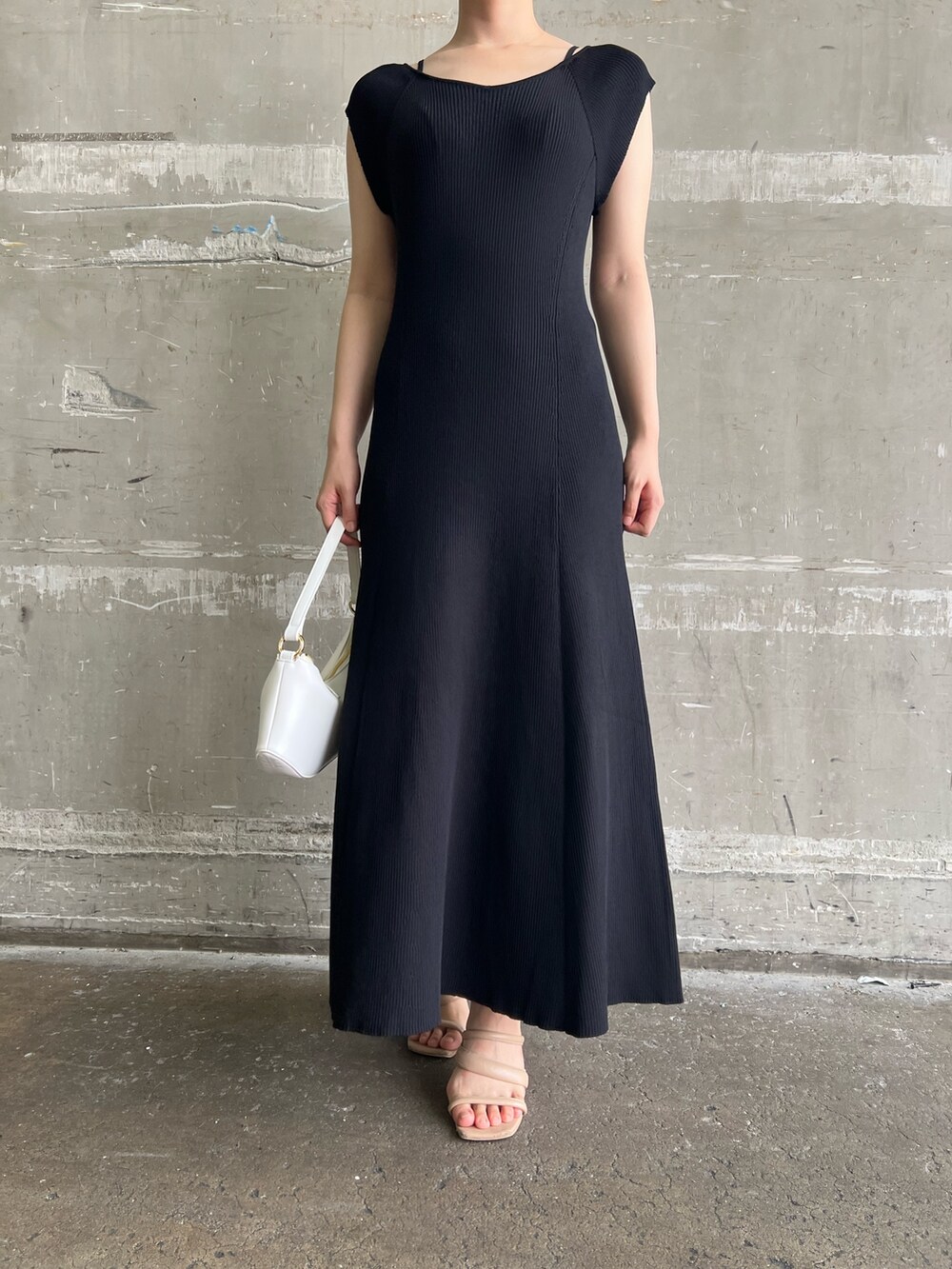 ブラック系のワンピース、ホワイト系のハンドバッグ、ベージュ系のサンダルを着用したレディースの夏コーディネートの6枚目の写真