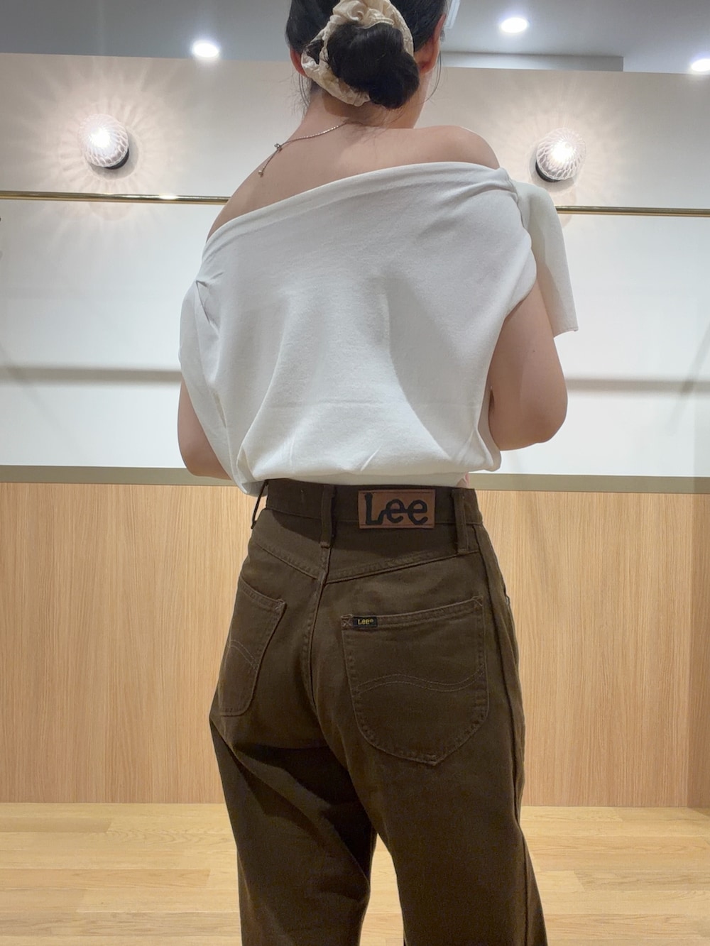 ブラウン系のデニムパンツ、オレンジ系のサンダル、ホワイト系のニット/セーターを着用したレディースの夏コーディネートの5枚目の写真