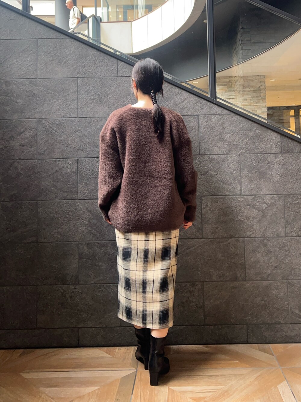 ベージュ系のスカート、ブラック系のニット/セーター、ブラウン系のカーディガン/ボレロを着用したレディースの秋コーディネートの3枚目の写真