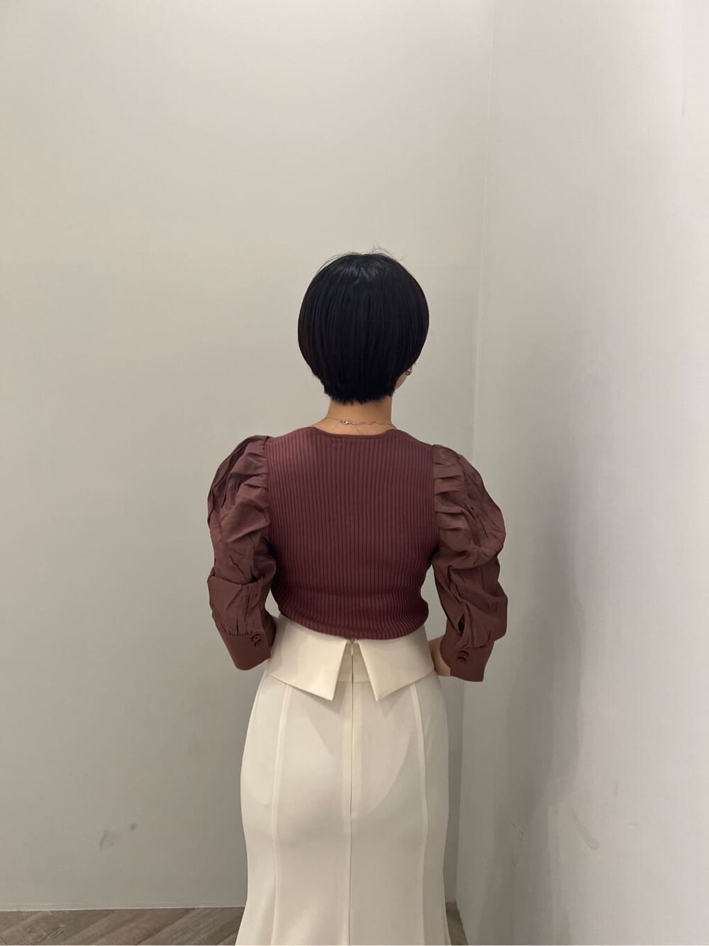 ブラウン系のパンプス、ホワイト系のスカート、ブラウン系のニット/セーターを着用したレディースの夏コーディネートの3枚目の写真