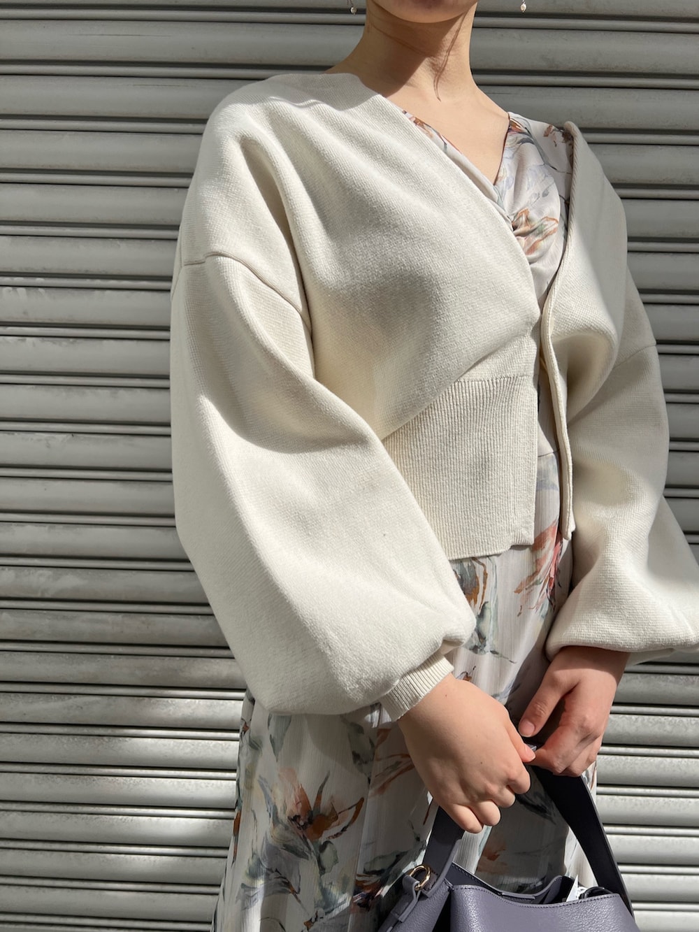 レッド系のブーツ、パープル系のハンドバッグ、ホワイト系のカーディガン/ボレロを着用したレディースの冬コーディネートの4枚目の写真