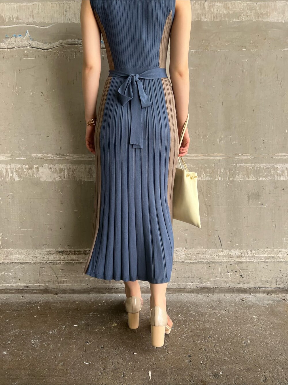 ホワイト系のハンドバッグ、ブルー系のワンピース、ゴールド系のピアス（両耳用）を着用したレディースの夏コーディネートの10枚目の写真