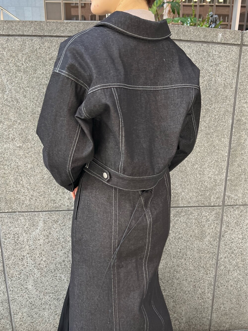 ブラック系のデニムスカート、ベージュ系のショルダーバッグ、レッド系のブーツを着用したレディースの冬コーディネートの5枚目の写真