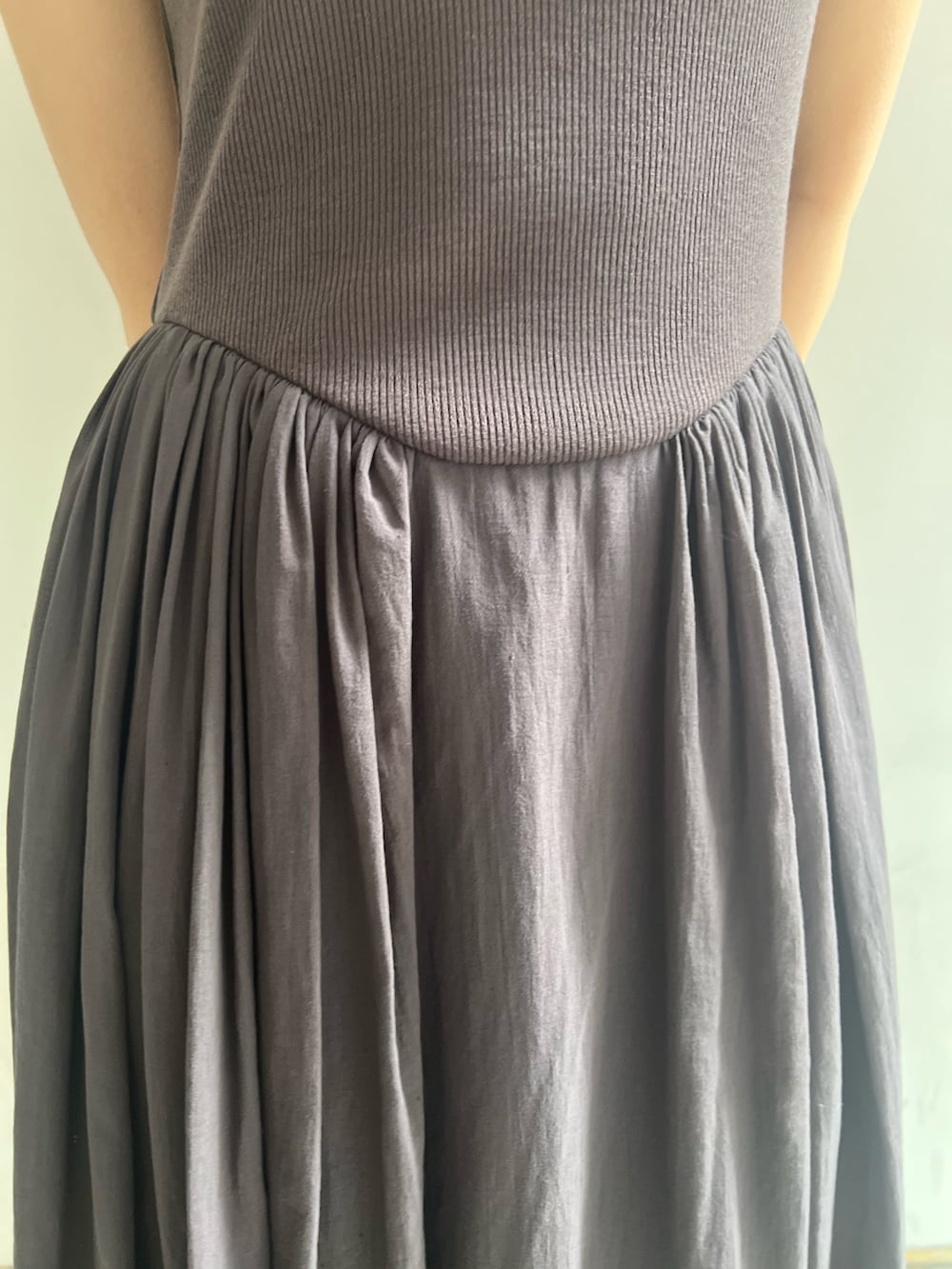 ブラック系のハンドバッグ、グレー系のワンピース、ホワイト系のテーラードジャケットを着用したレディースの春コーディネートの7枚目の写真