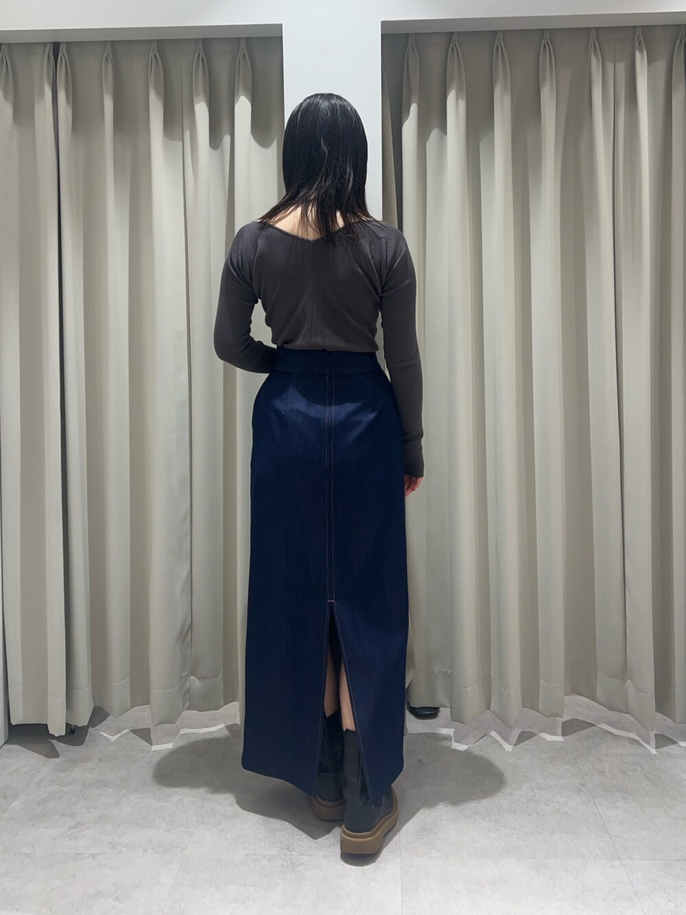 ブルー系のスカート、グレー系のニット/セーターを着用したレディースの春コーディネートの3枚目の写真