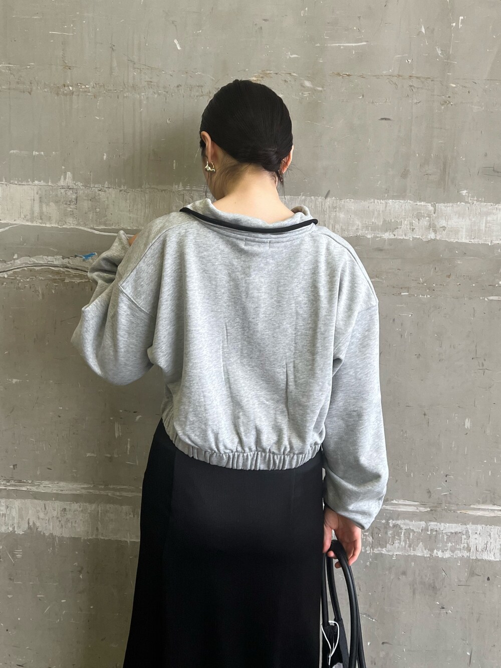 ブラック系のハンドバッグ、グレー系のスウェット、ブラック系のブーツを着用したレディースの秋コーディネートの5枚目の写真