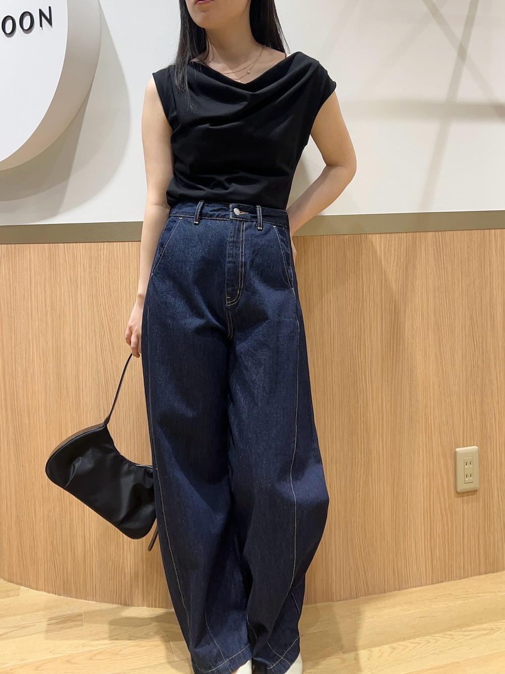 ブルー系のデニムパンツ、グリーン系のパンプス、ブラック系のTシャツ/カットソーを着用したレディースの春コーディネートの3枚目の写真