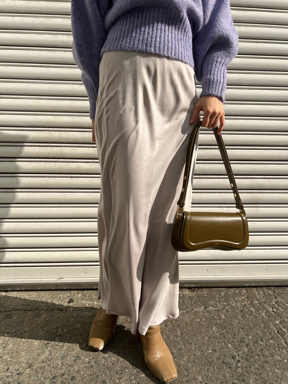 ブラウン系のショルダーバッグ、ベージュ系のブーツ、ベージュ系のダウンジャケット/コートを着用したレディースの冬コーディネートの9枚目の写真