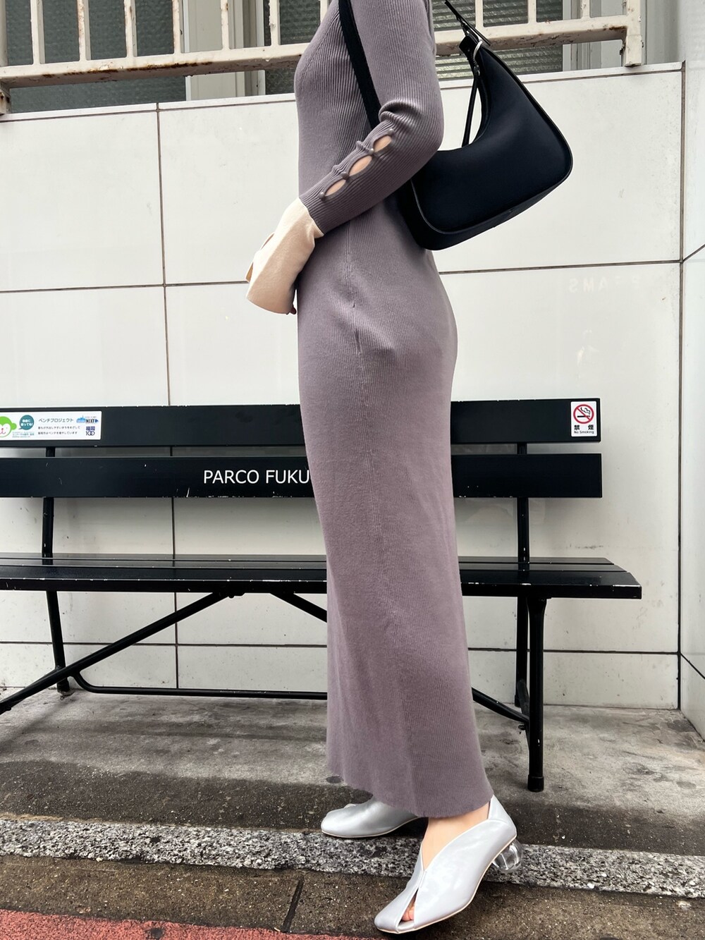 ブラック系のハンドバッグ、グレー系のワンピース、シルバー系のパンプスを着用したレディースの冬コーディネートの6枚目の写真