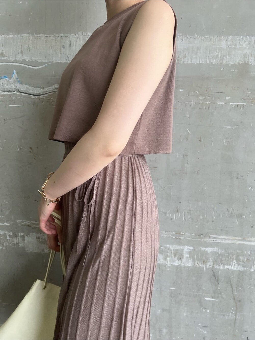 ホワイト系のハンドバッグ、ホワイト系のサンダル、ブラウン系のワンピースを着用したレディースの夏コーディネートの6枚目の写真