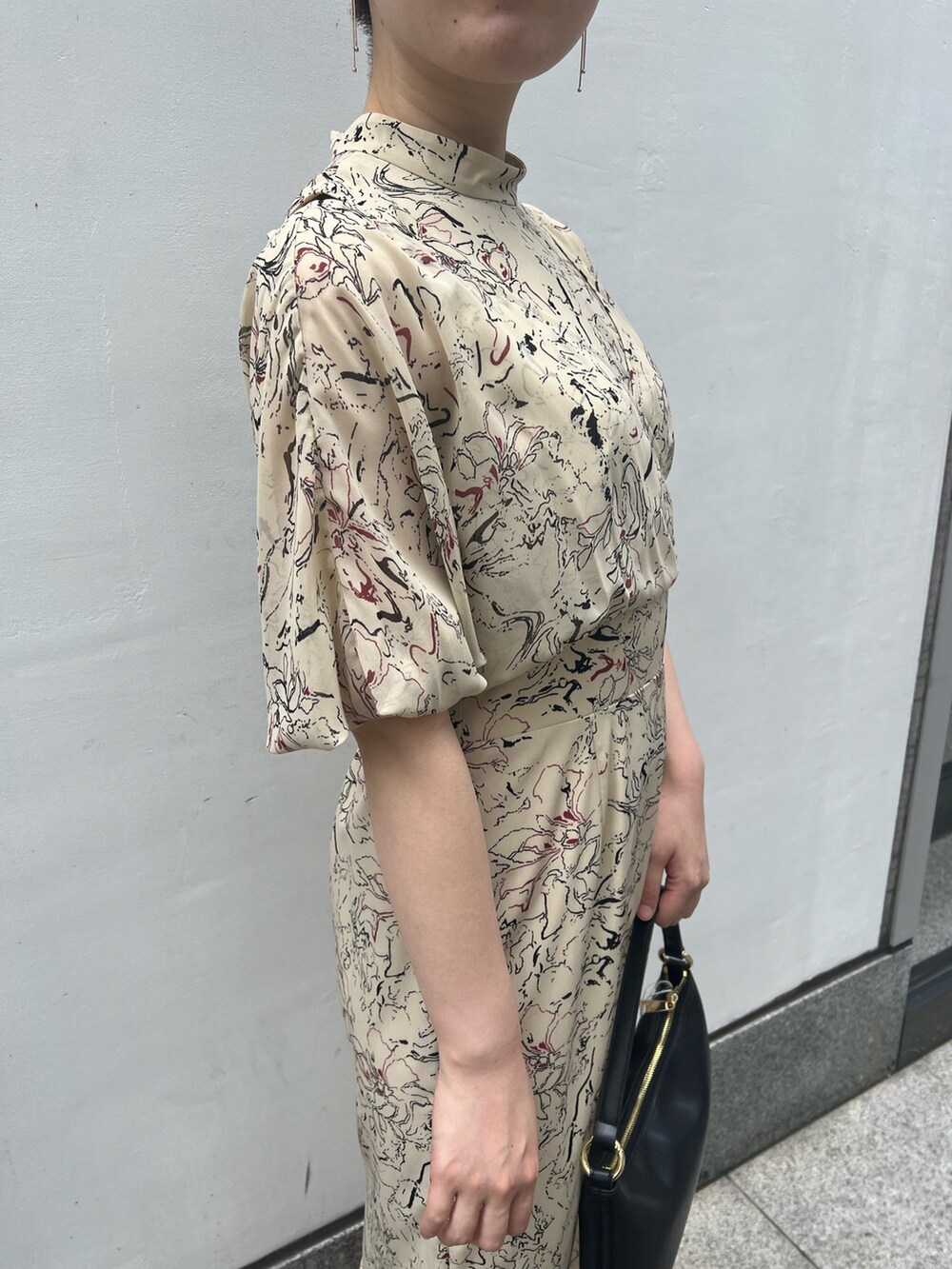 ブラック系のハンドバッグ、その他のサンダル、ベージュ系のワンピースを着用したレディースの夏コーディネートの4枚目の写真