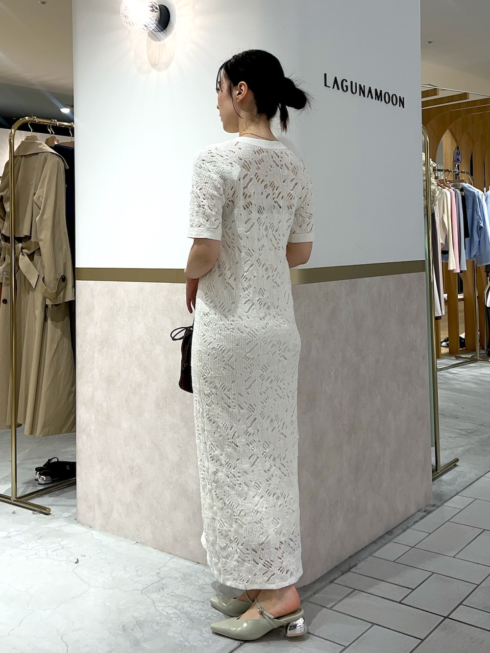 ホワイト系のワンピース、グリーン系のパンプス、ブラウン系のハンドバッグを着用したレディースの春コーディネートの2枚目の写真