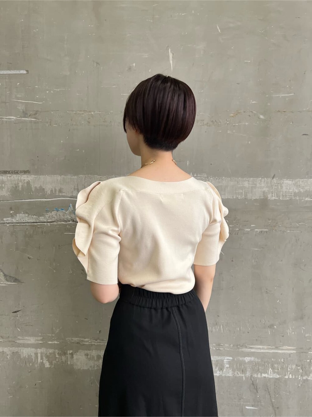 ベージュ系のハンドバッグ、ブラック系のスカート、ホワイト系のニット/セーターを着用したレディースの夏コーディネートの6枚目の写真