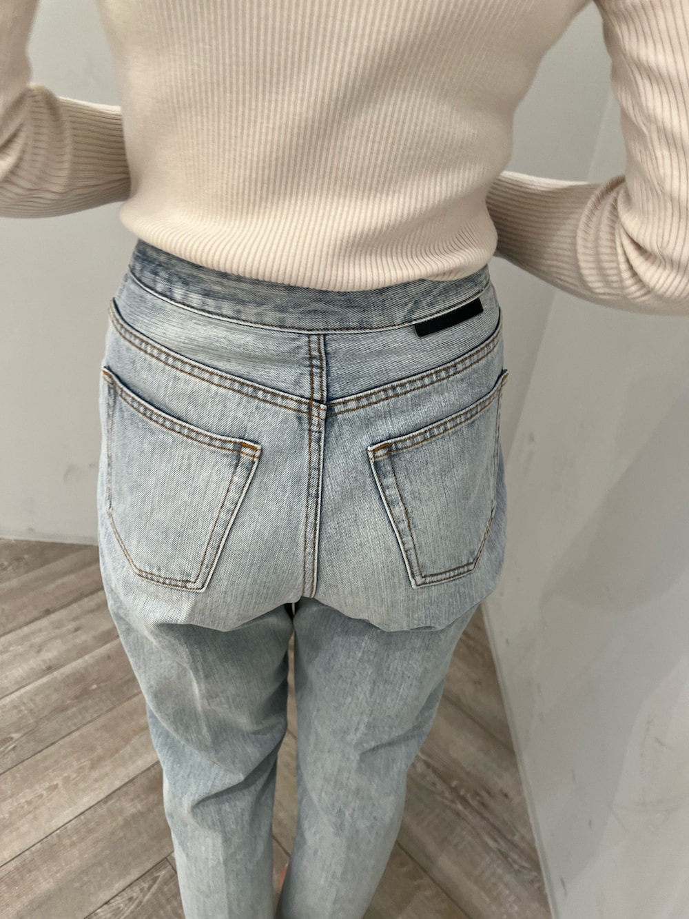 ホワイト系のニット/セーター、ブルー系のデニムパンツ、ホワイト系のパンプスを着用したレディースの春コーディネートの6枚目の写真