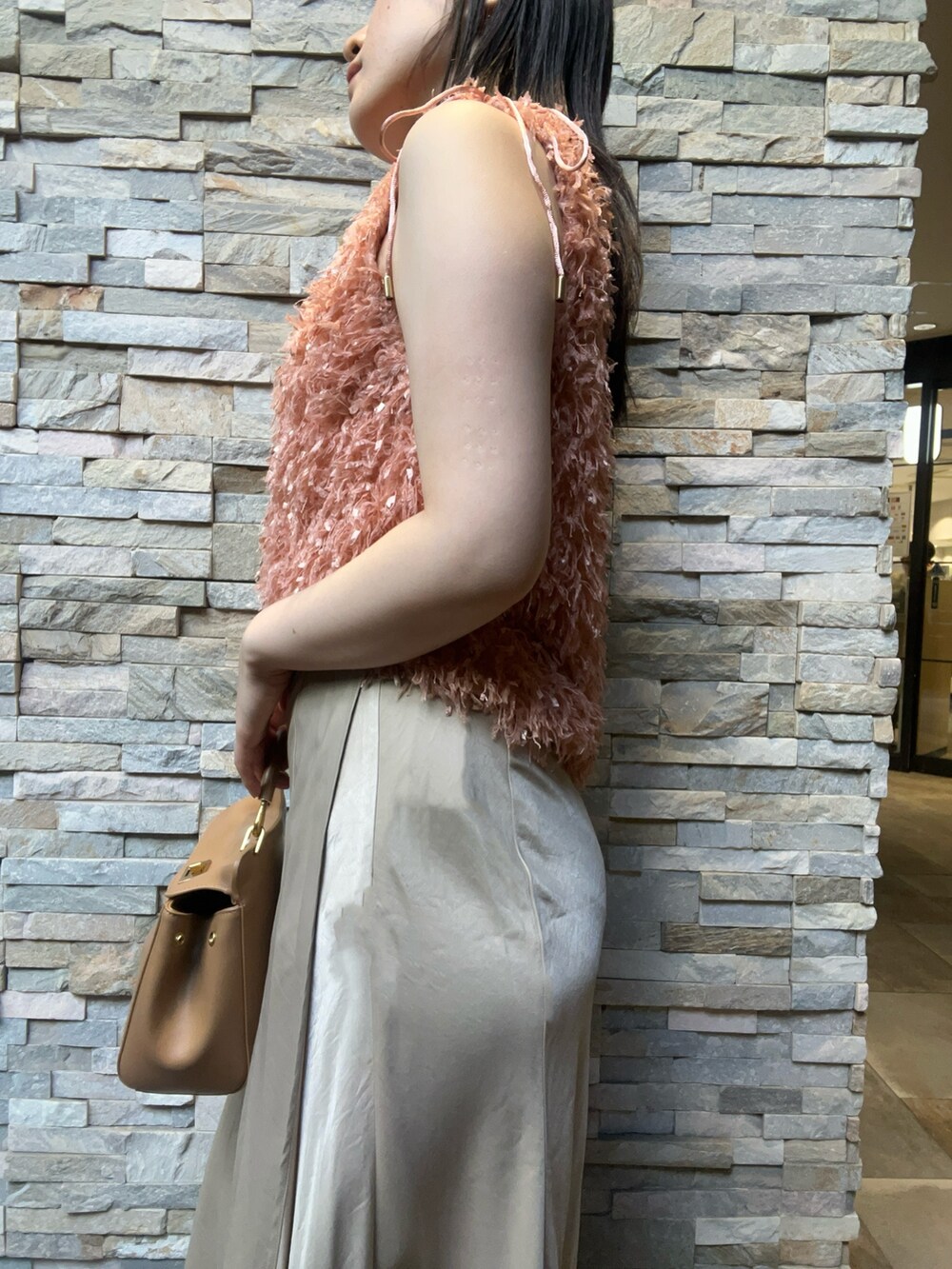 オレンジ系のTシャツ/カットソー、ベージュ系のスカート、ホワイト系のサンダルを着用したレディースの夏コーディネートの5枚目の写真