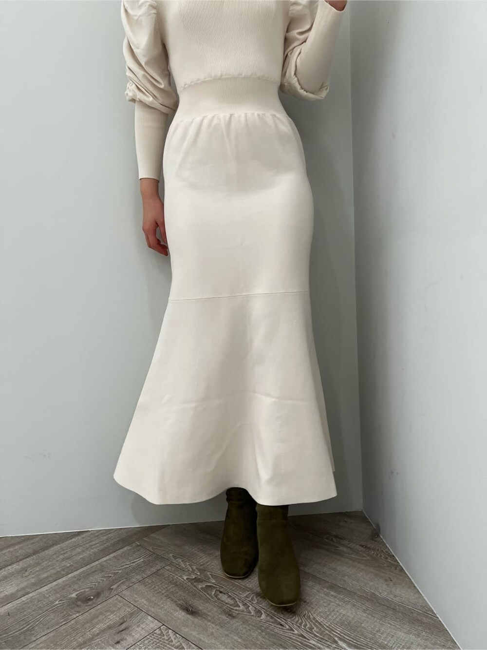 ベージュ系のブーツ、ホワイト系のワンピースを着用したレディースの冬コーディネートの7枚目の写真