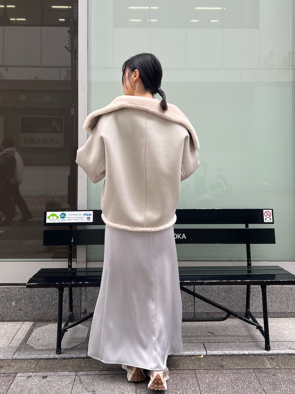 ホワイト系のムートンコート、グレー系のスカートを着用したレディースの冬コーディネートの3枚目の写真