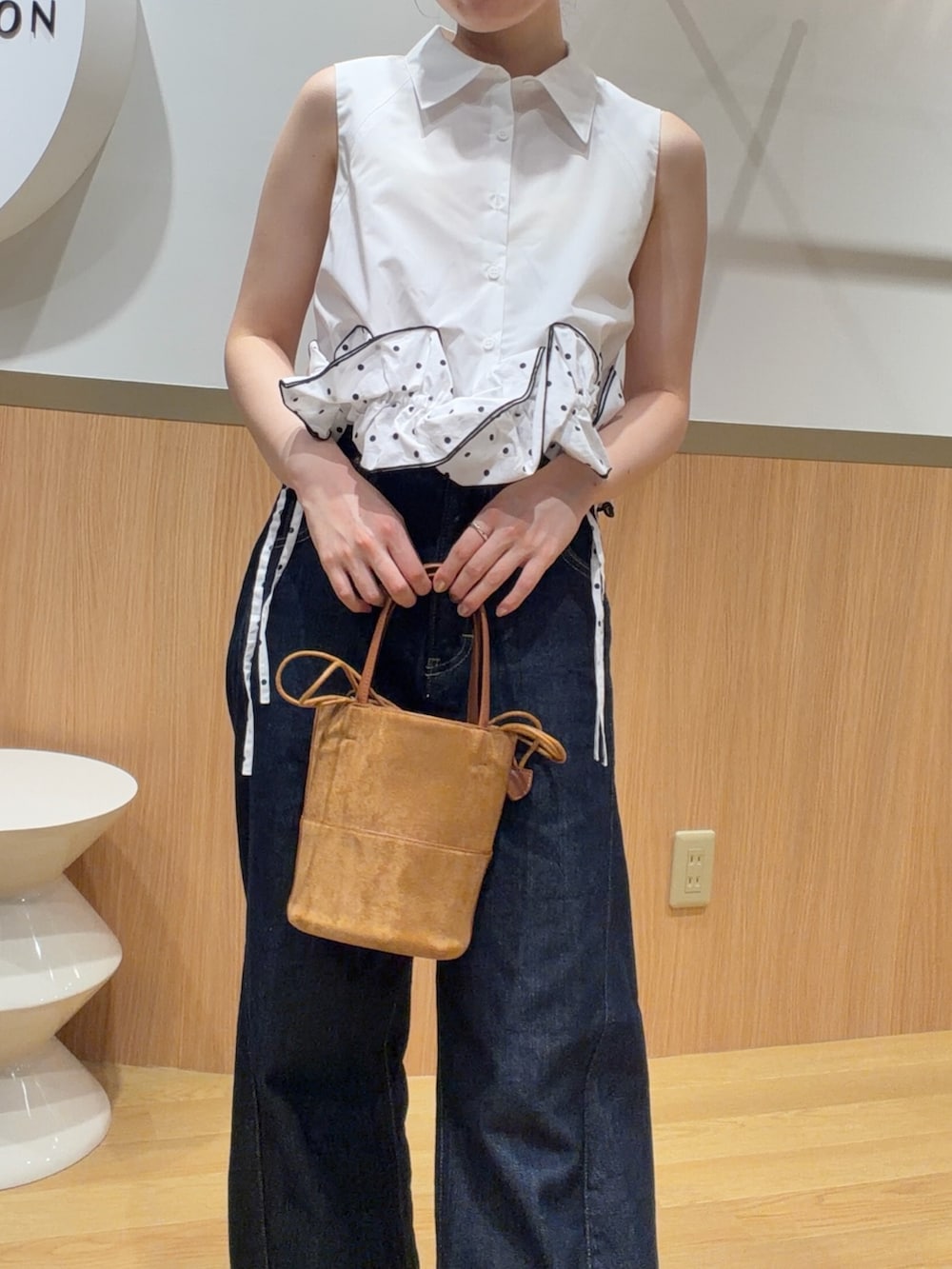 ブルー系のデニムパンツ、オレンジ系のサンダル、ホワイト系のシャツ/ブラウスを着用したレディースの夏コーディネートの6枚目の写真