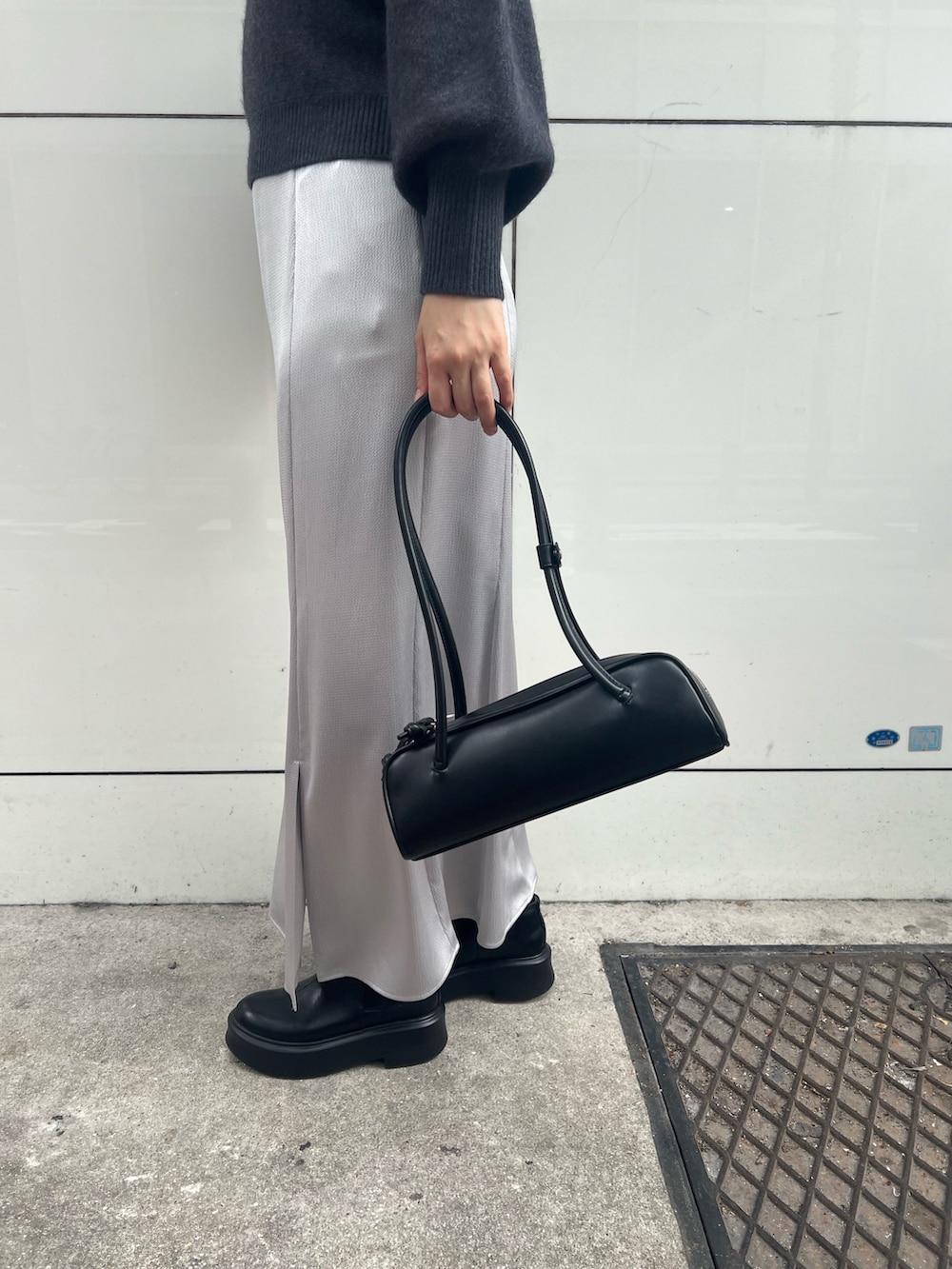 グレー系のニット/セーター、グレー系のカーディガン/ボレロ、ブラック系のスカートを着用したレディースの秋コーディネートの6枚目の写真