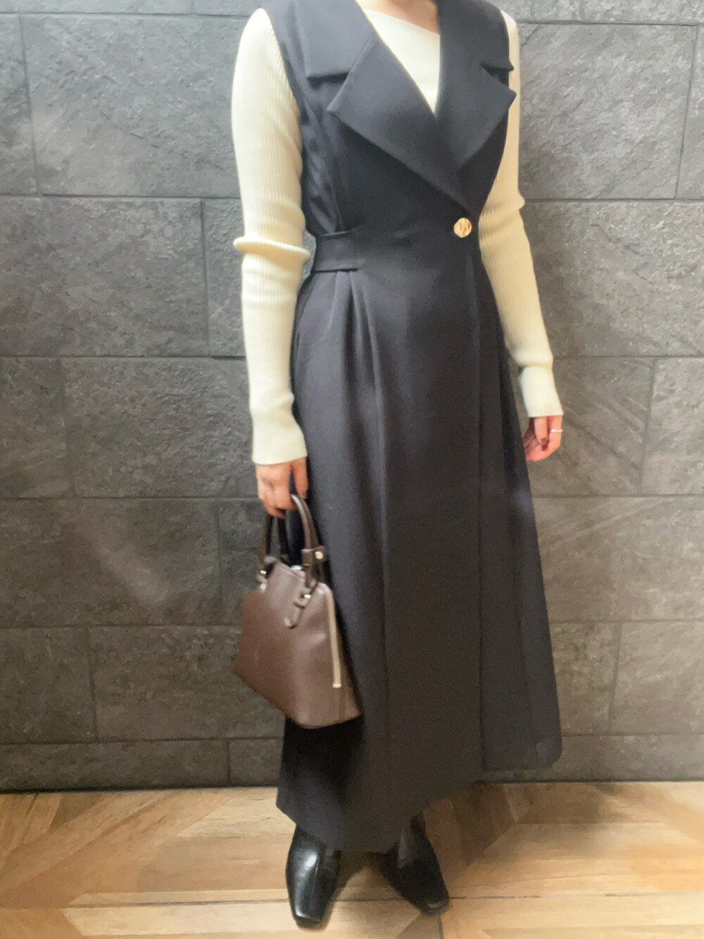 ブラック系のワンピース、ホワイト系のニット/セーター、ブラック系のブーツを着用したレディースの秋コーディネートの5枚目の写真