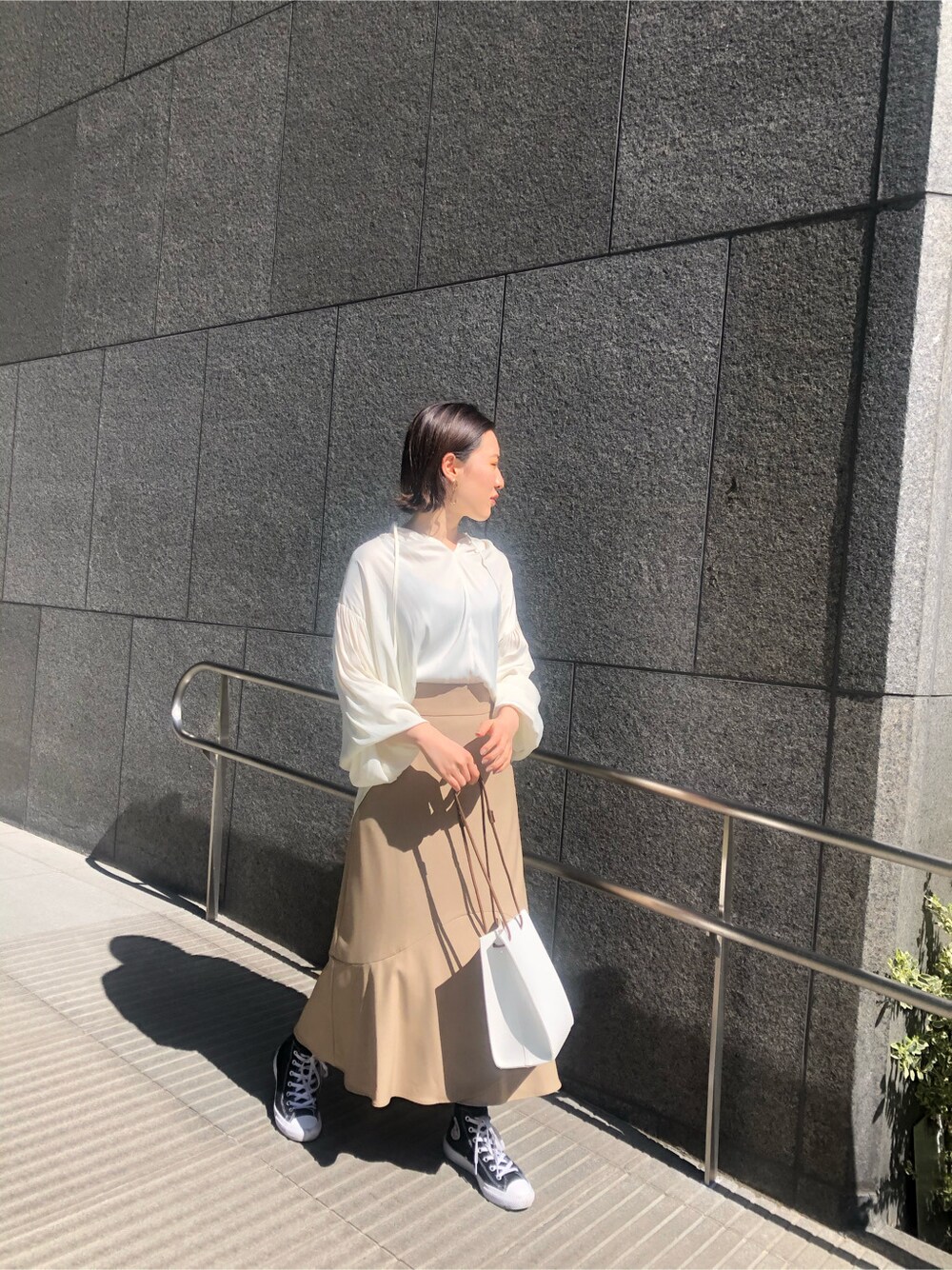 ホワイト系のシャツ/ブラウス、ベージュ系のスカート、ホワイト系のハンドバッグを着用したレディースの春コーディネートの4枚目の写真