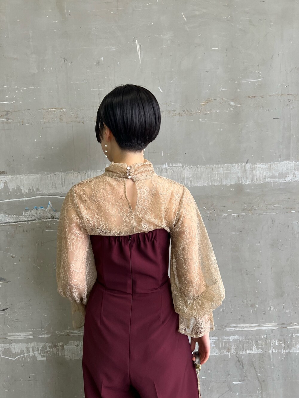 ホワイト系のノーカラーコート、シルバー系のハンドバッグ、シルバー系のパンプスを着用したレディースの冬コーディネートの7枚目の写真