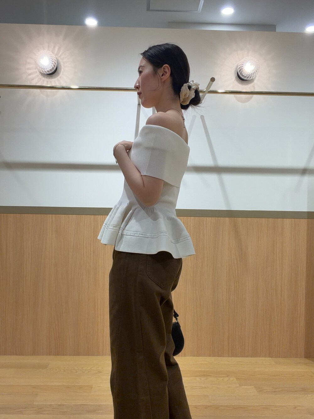 ブラウン系のデニムパンツ、ホワイト系のニット/セーター、ブラウン系のサンダルを着用したレディースの夏コーディネートの5枚目の写真