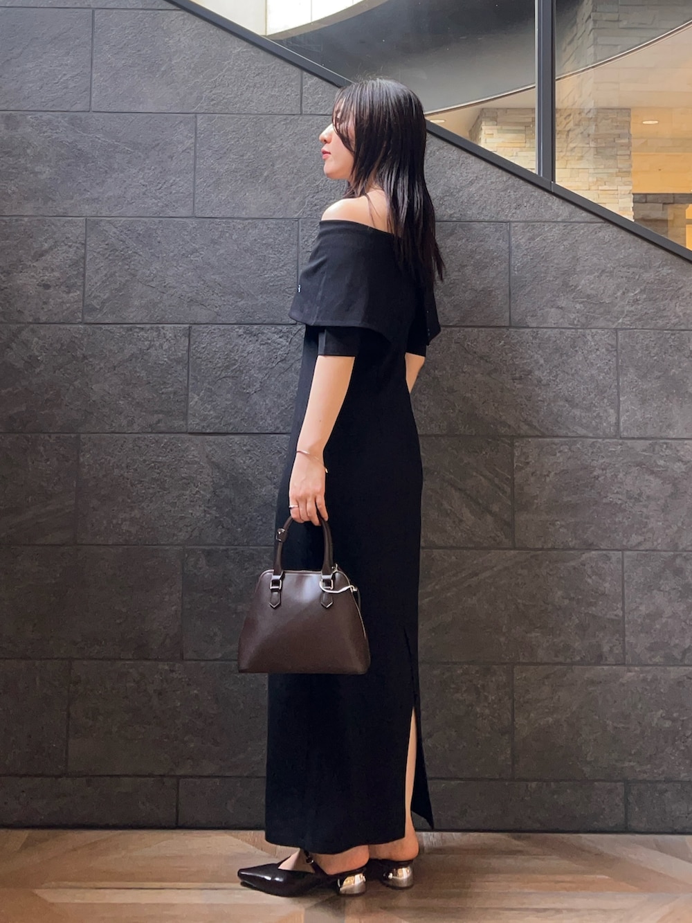 ブラウン系のボストンバッグ、ブラック系のワンピース、ブラウン系のパンプスを着用したレディースの夏コーディネートの2枚目の写真