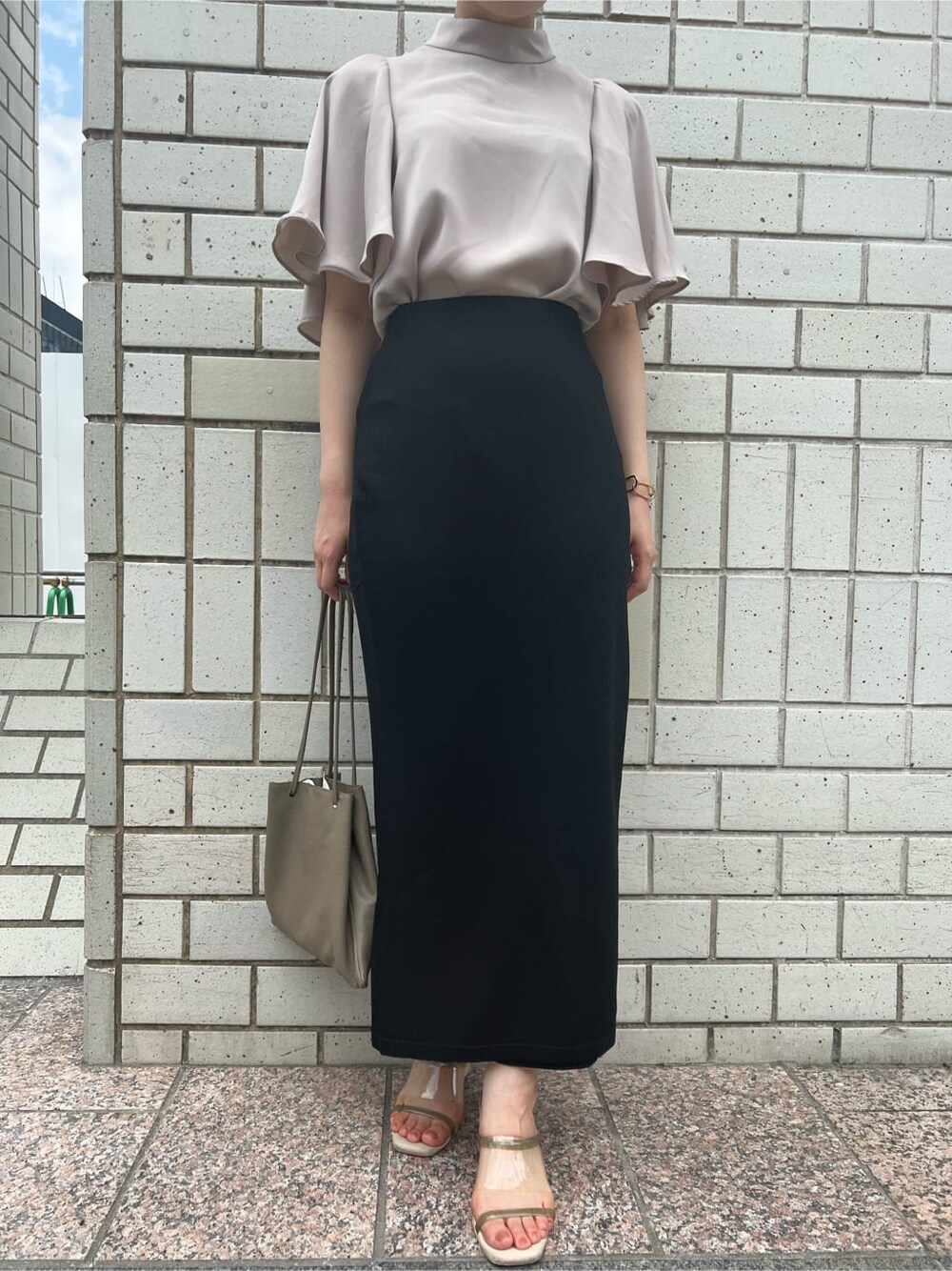 ベージュ系のハンドバッグ、グリーン系のサンダル、ブラック系のスカートを着用したレディースの夏コーディネートの9枚目の写真