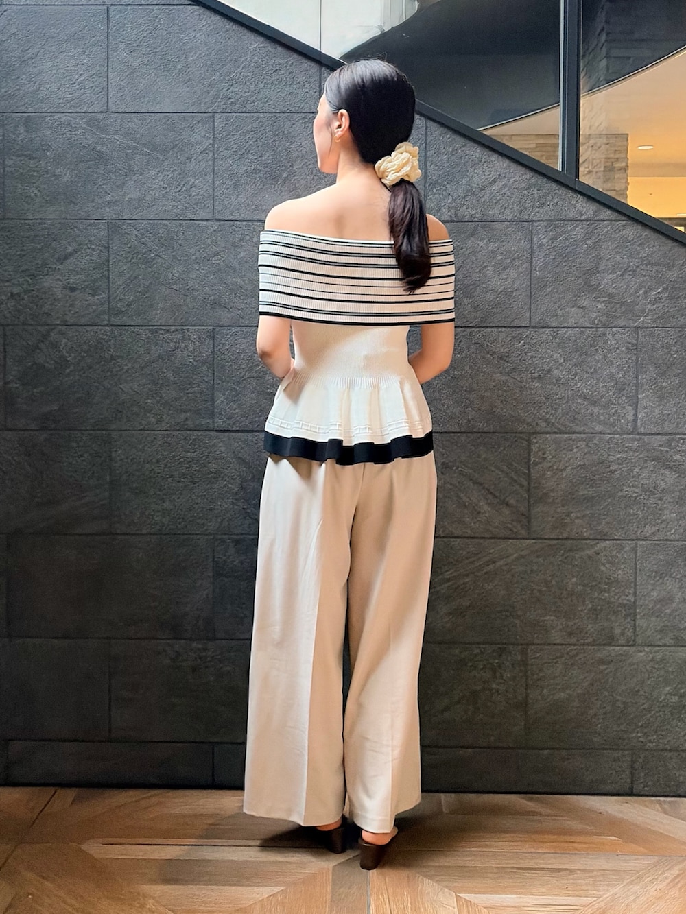 ホワイト系のニット/セーター、ホワイト系のその他パンツ、ブラック系のサンダルを着用したレディースの夏コーディネートの3枚目の写真