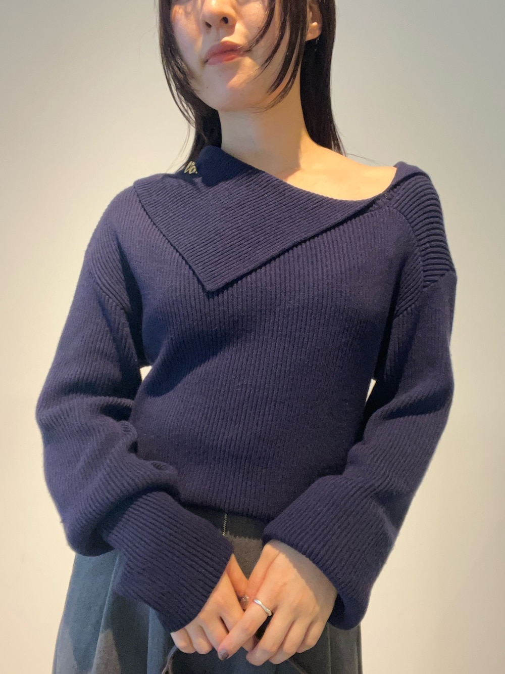 イエロー系のハンドバッグ、ブルー系のニット/セーター、ブラウン系のパンプスを着用したレディースの秋コーディネートの4枚目の写真