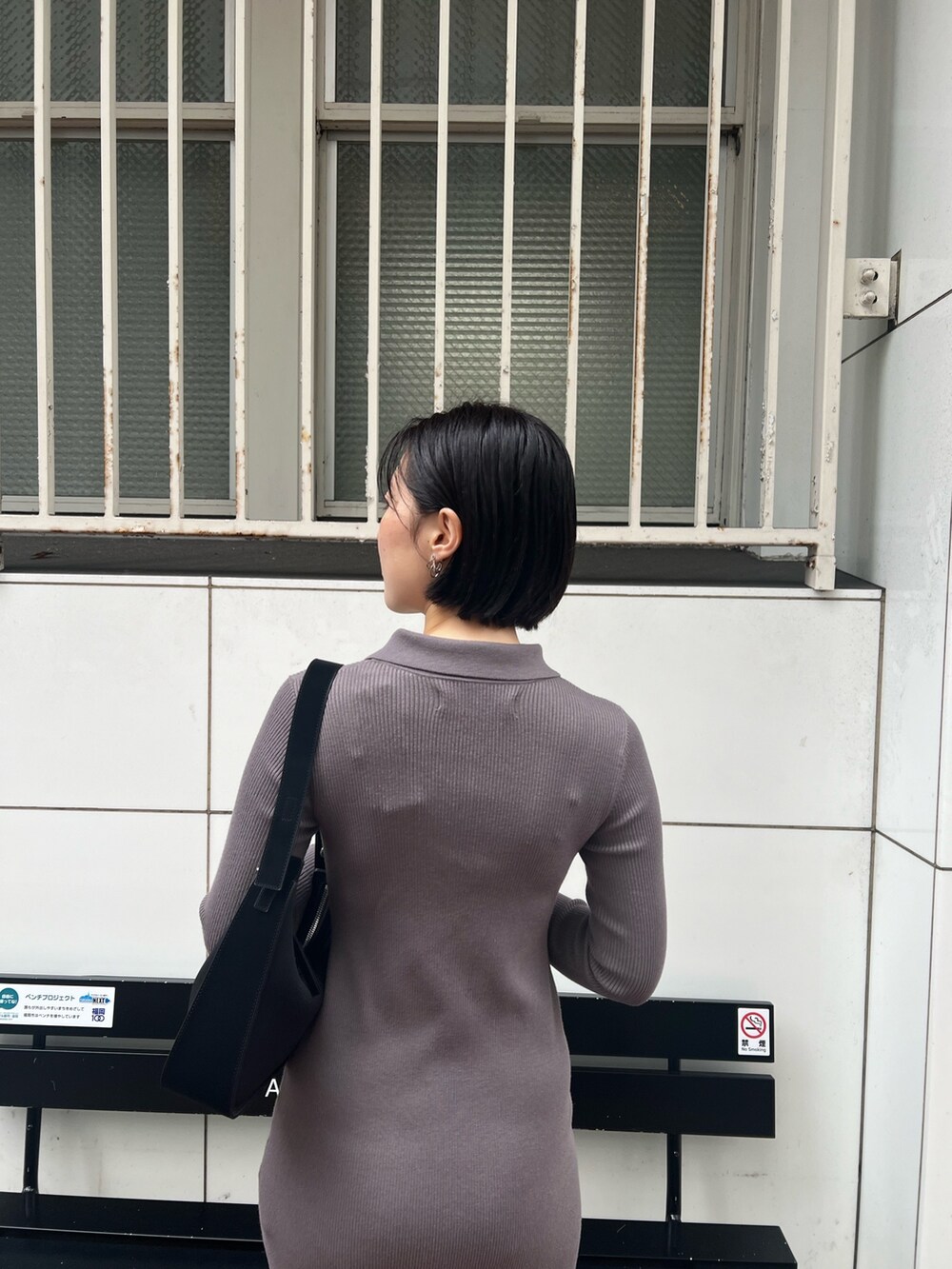 ブラック系のハンドバッグ、グレー系のワンピース、シルバー系のパンプスを着用したレディースの冬コーディネートの5枚目の写真