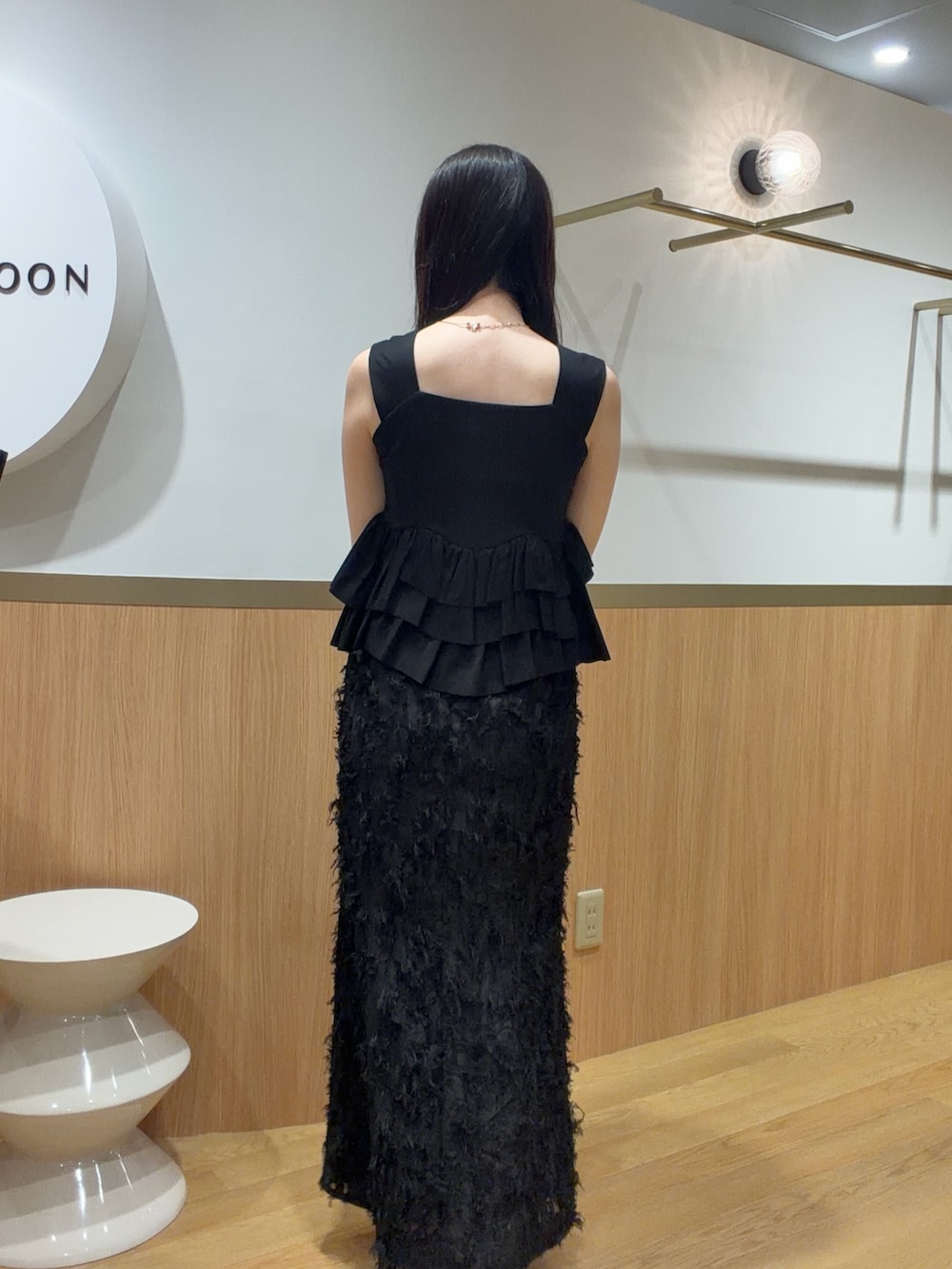 ブラック系のスカート、ブラック系のタンクトップ、ベージュ系のサンダルを着用したレディースの春コーディネートの5枚目の写真