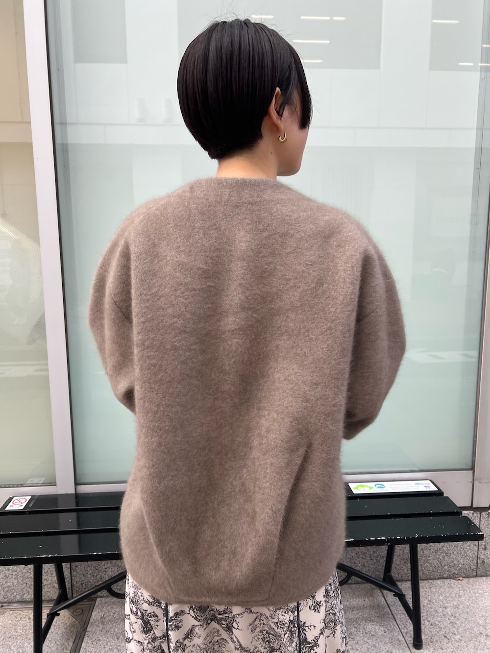 レッド系のブーツ、ホワイト系のハンドバッグ、ベージュ系のカーディガン/ボレロを着用したレディースの冬コーディネートの3枚目の写真