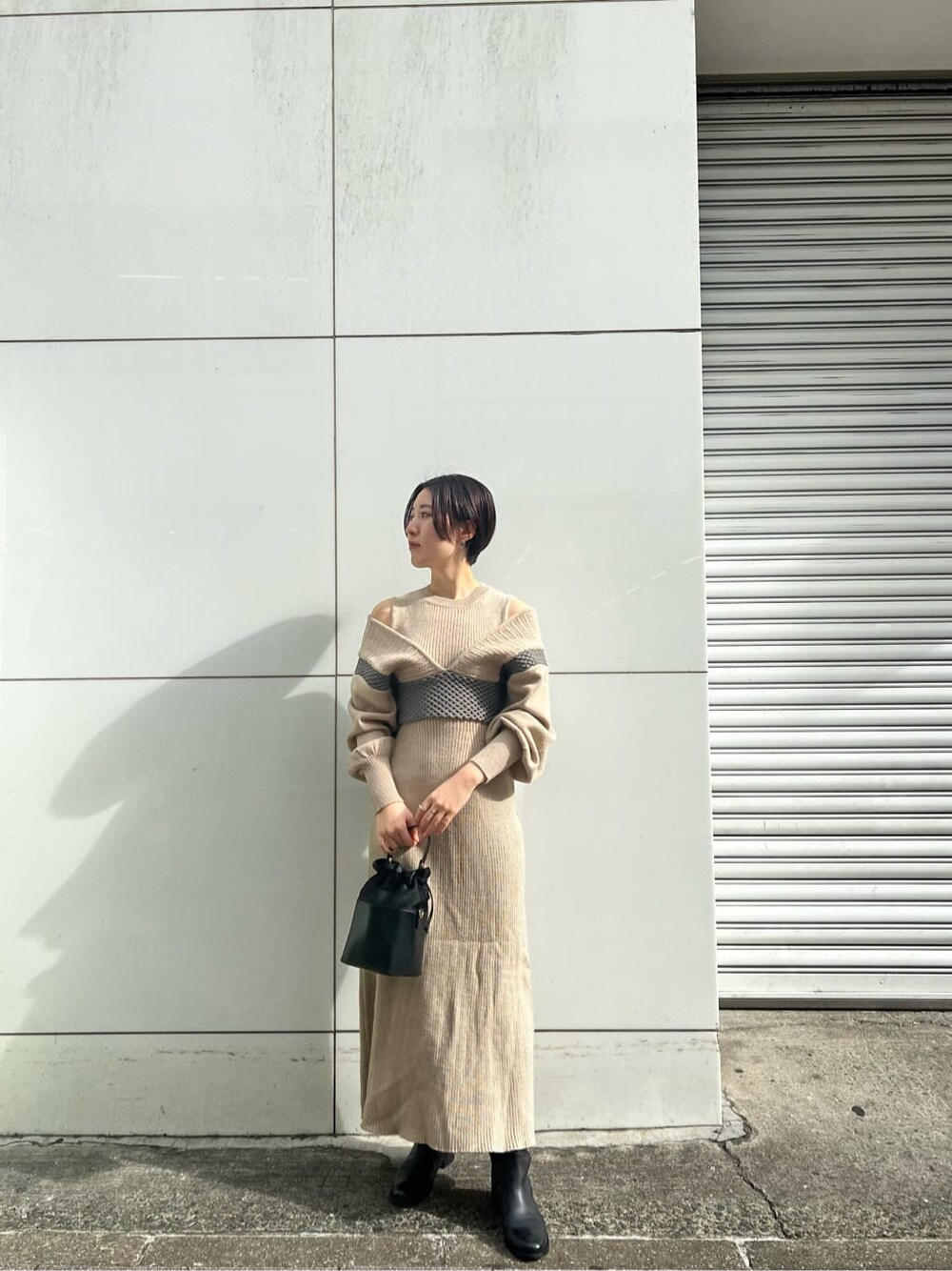 ブラック系のその他シューズ、ベージュ系のワンピース、パープル系のその他アウターを着用したレディースの冬コーディネートの2枚目の写真