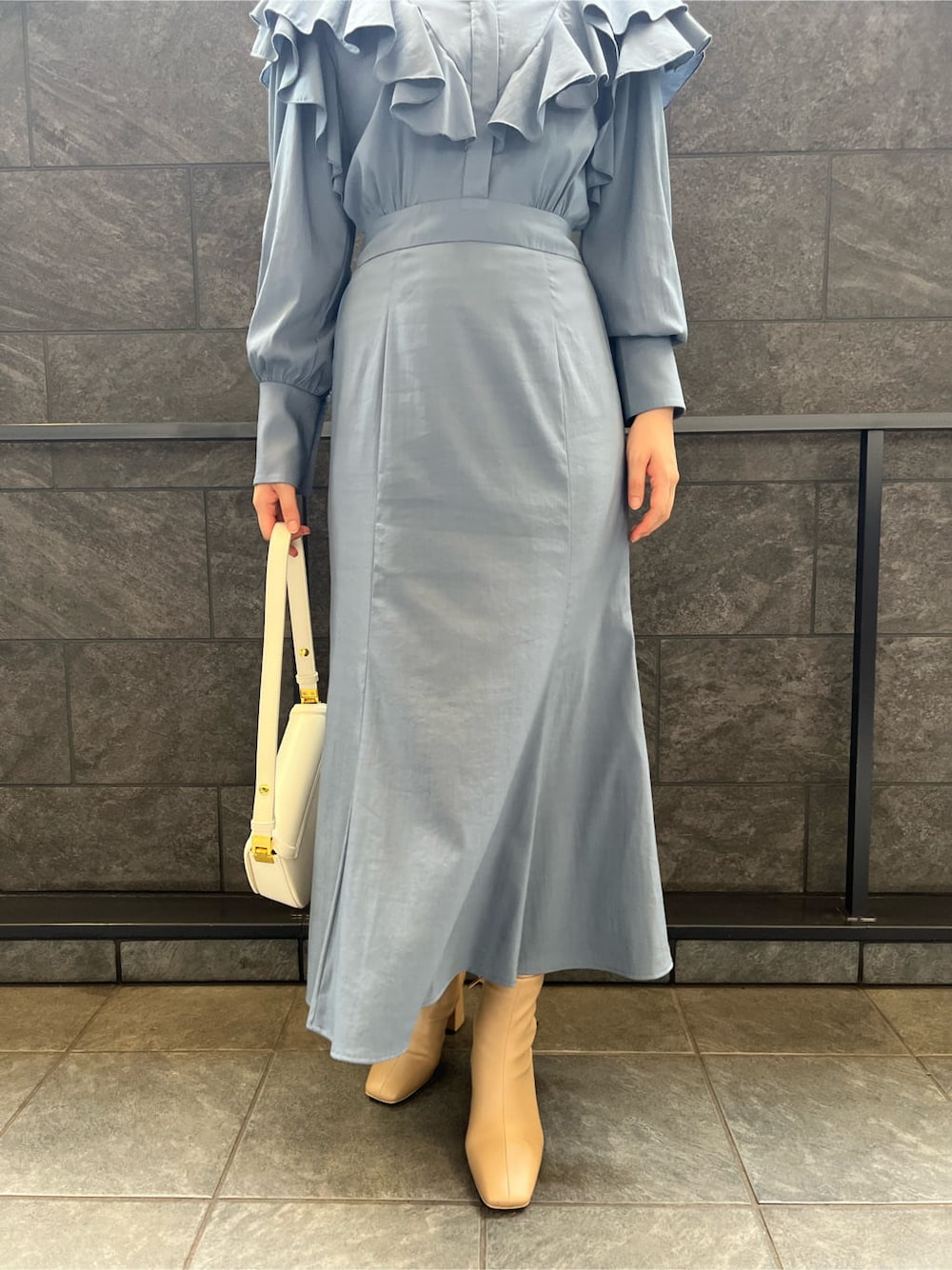 ベージュ系のブーツ、ブルー系のワンピース、ホワイト系のショルダーバッグを着用したレディースの夏コーディネートの7枚目の写真